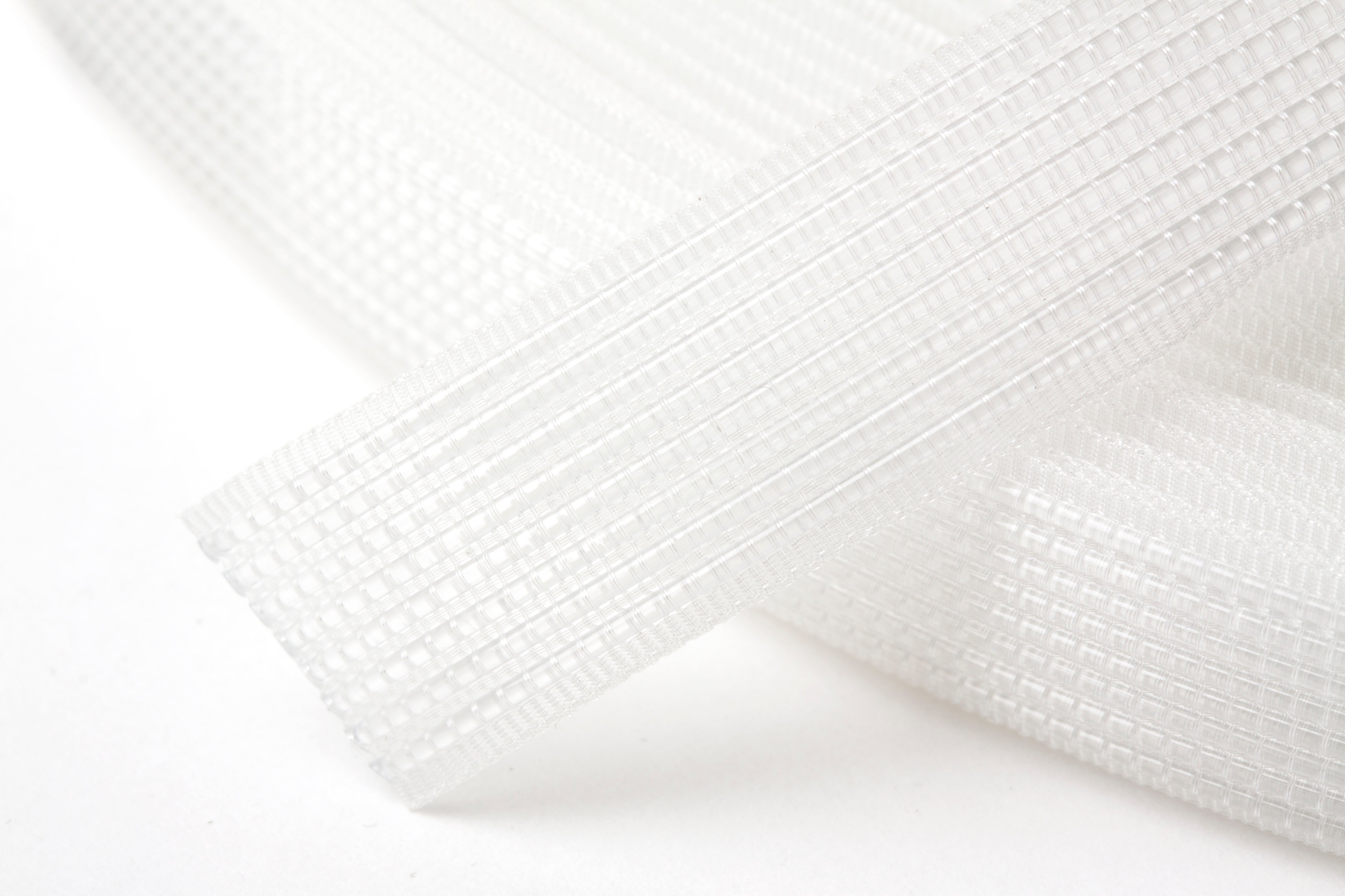 A roll of 12mm transparent polyester sew-in boning with a flexible mesh structure.