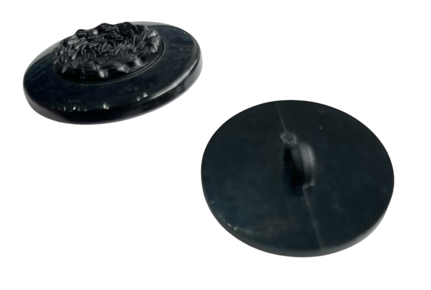 Two black polyester buttons, one with a decorative embossed design.