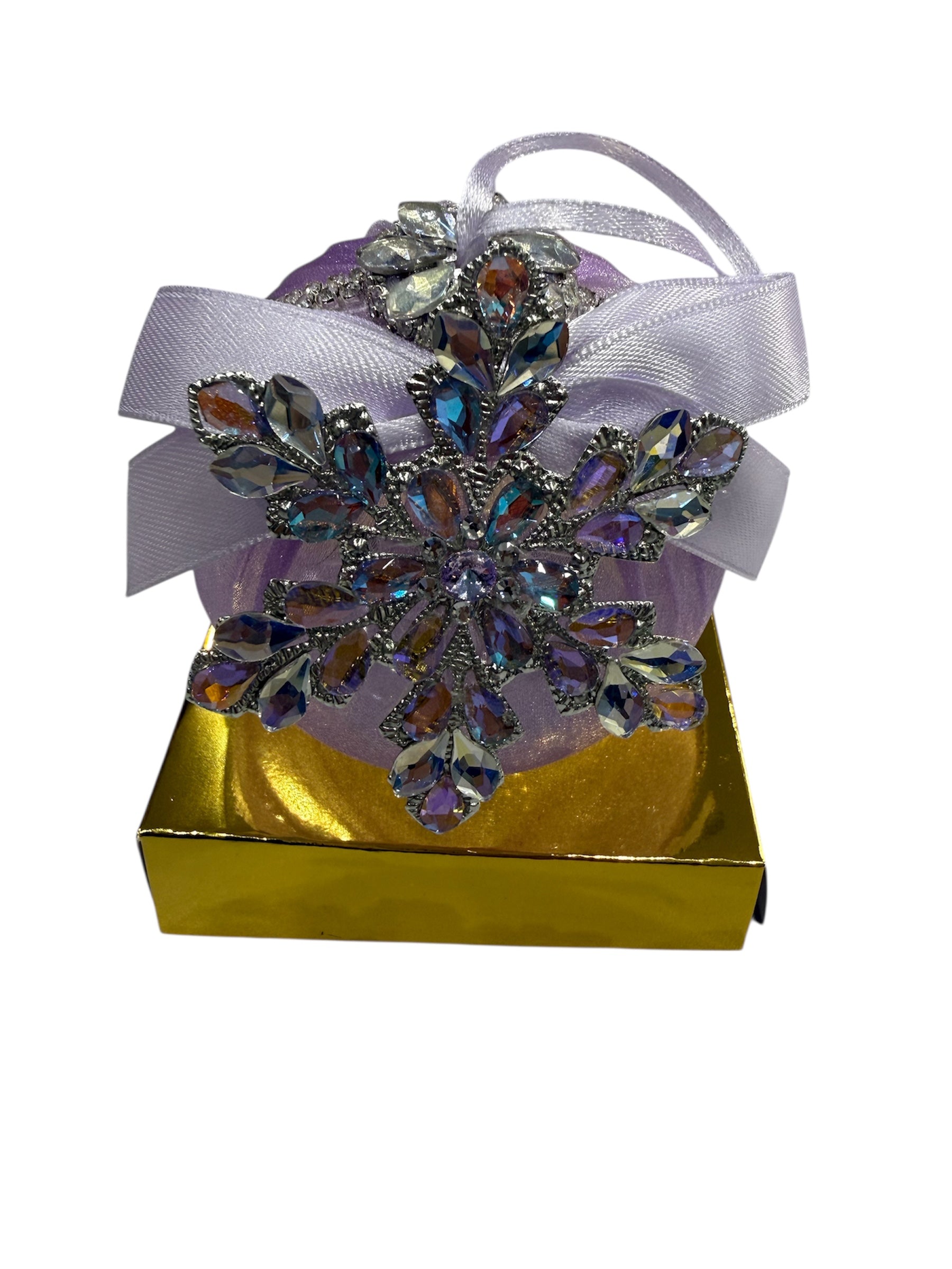 Round hand-embroidered Christmas ornament with snowflake embellishment on a gold box.