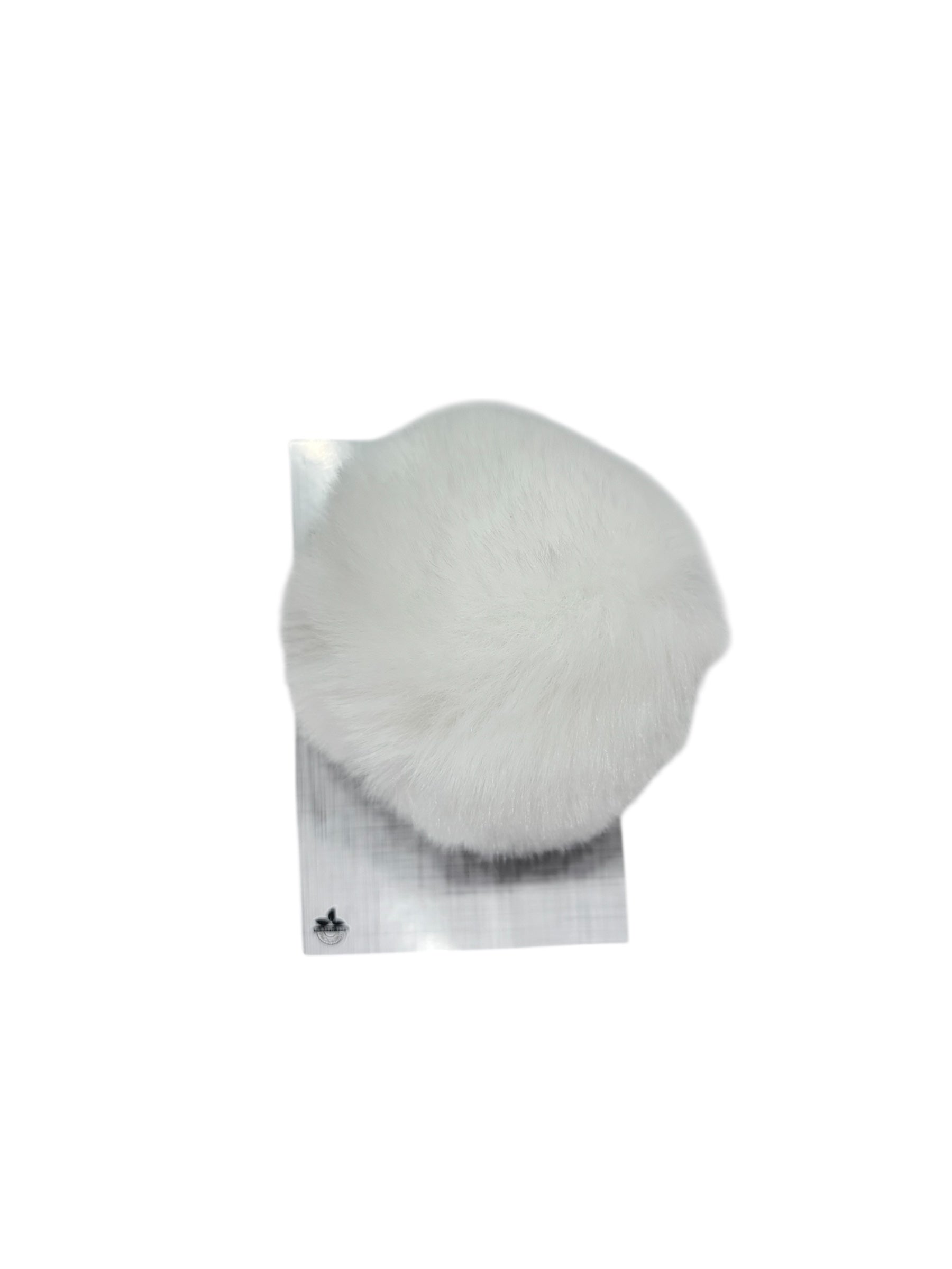 A white faux fur pompom sits on a silver stand with a small logo.
