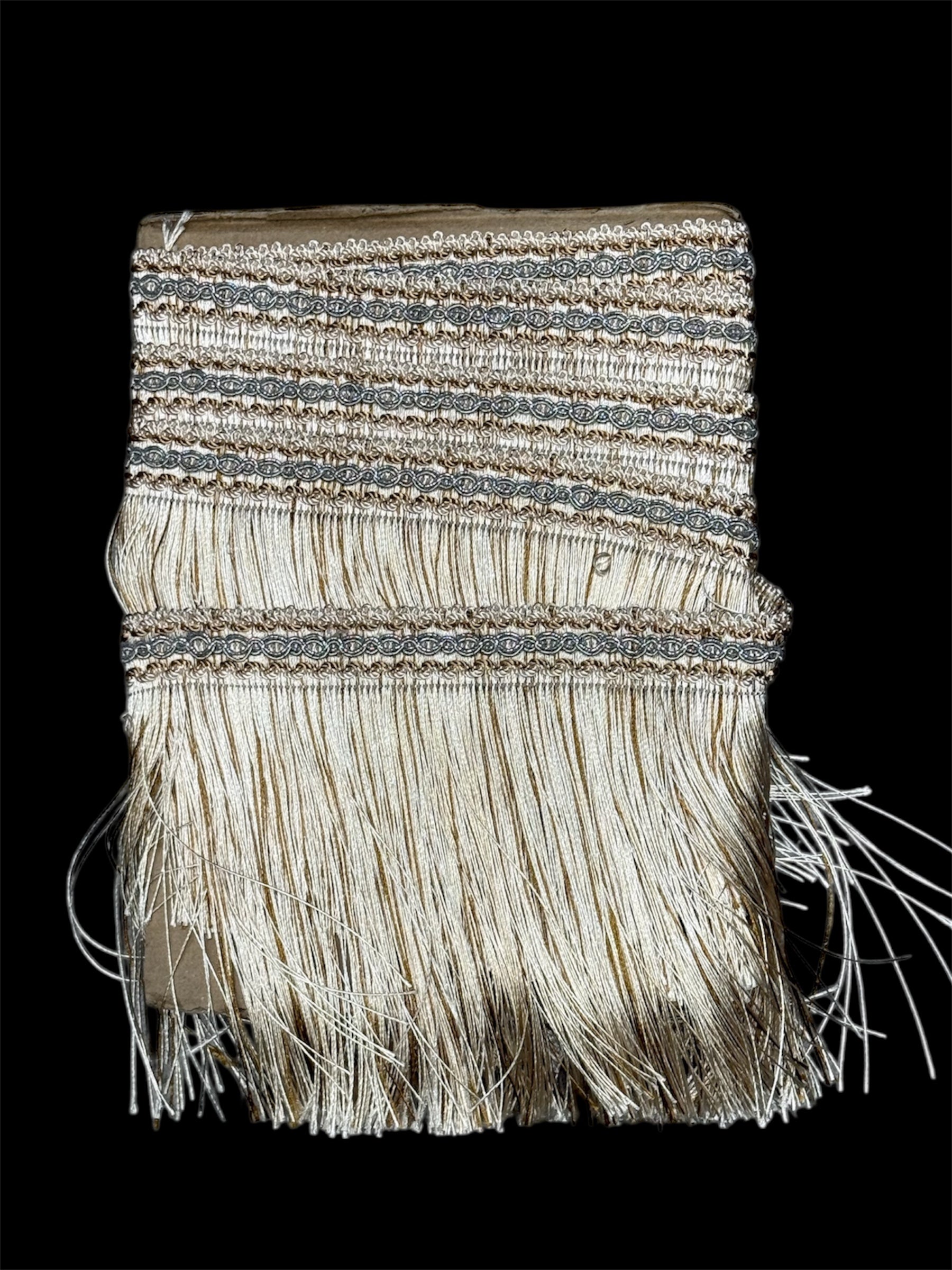 Gold and silver metallic bullion fringe trim with a decorative woven band and long, flowing fringes.