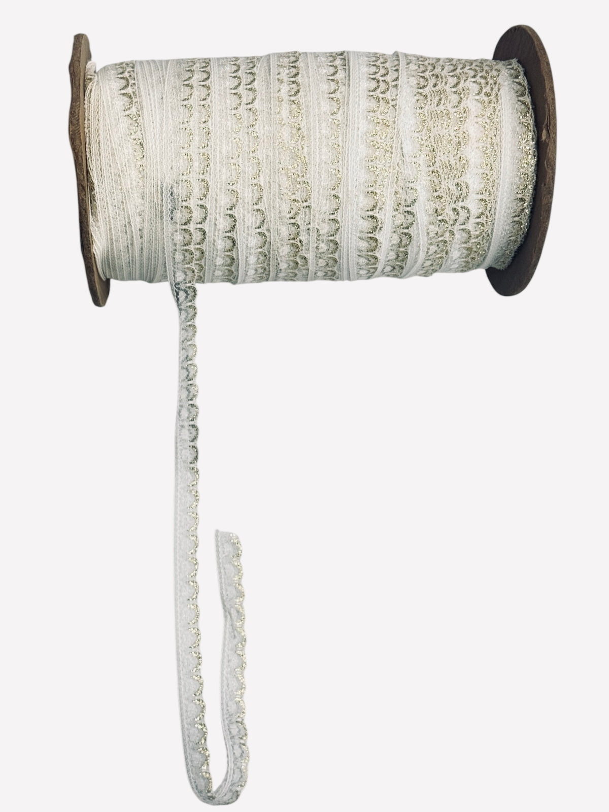 White crochet lace ribbon with gold metallic scalloped edge on a wooden spool.