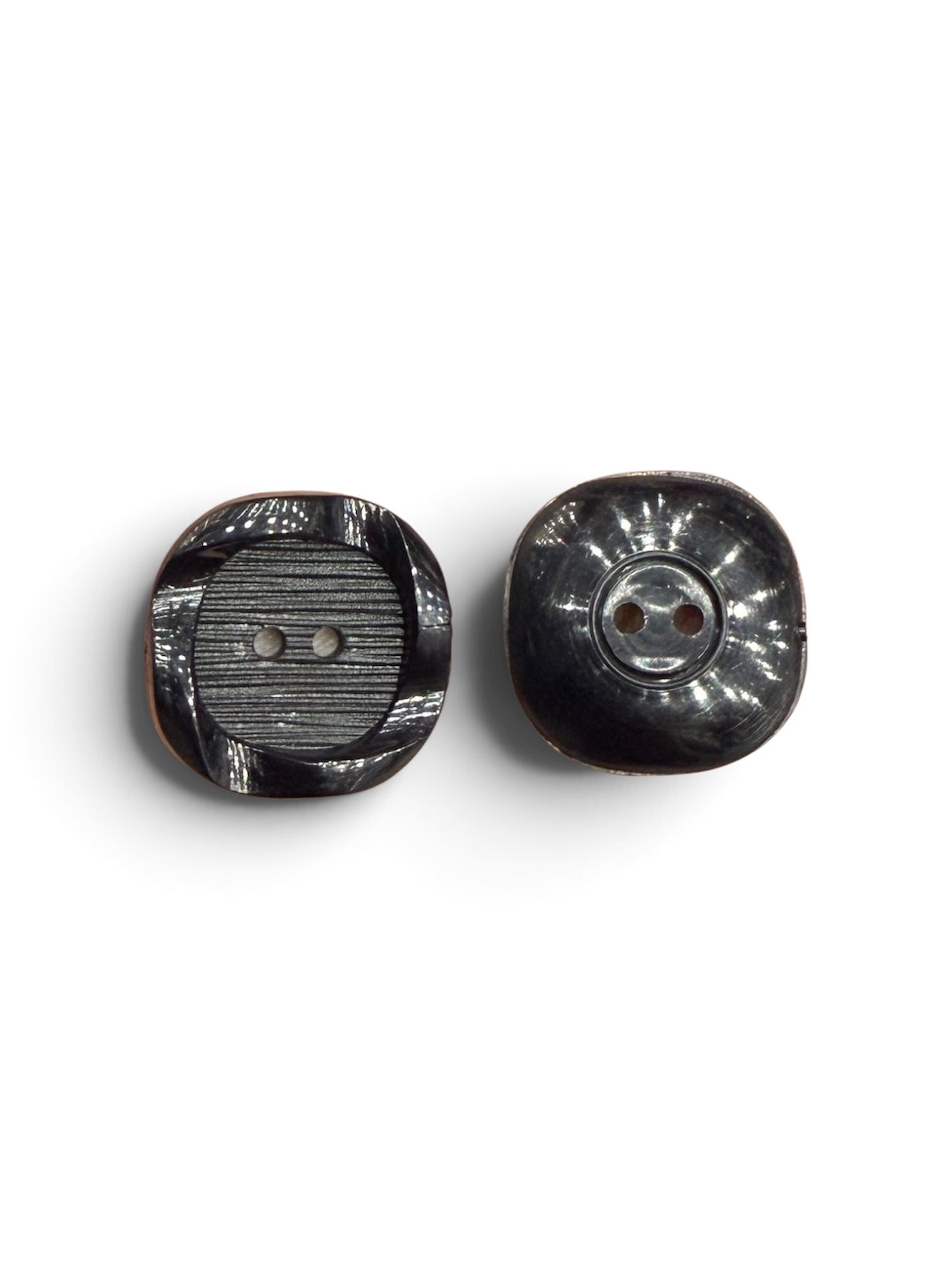 Two 21mm black textured resin 2-hole sewing buttons showing front and back details.