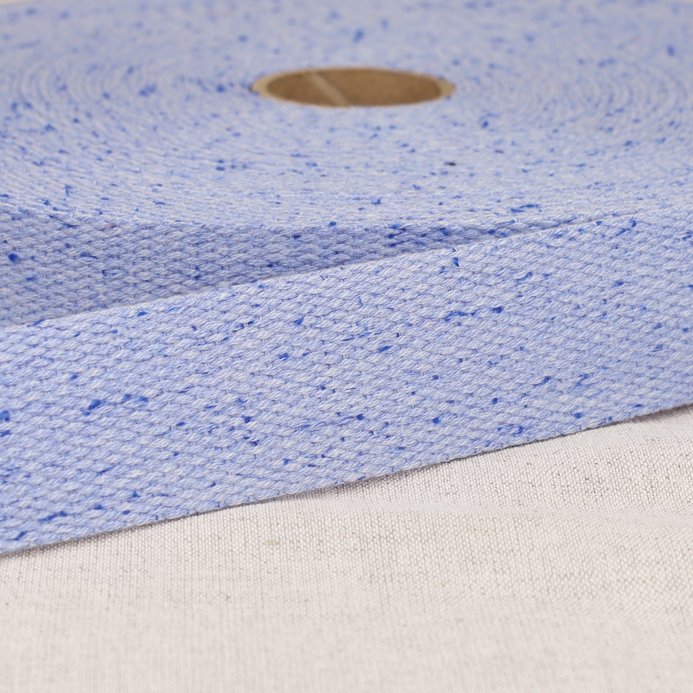 A roll of 20mm light blue mottled polyester webbing strap with a textured weave.