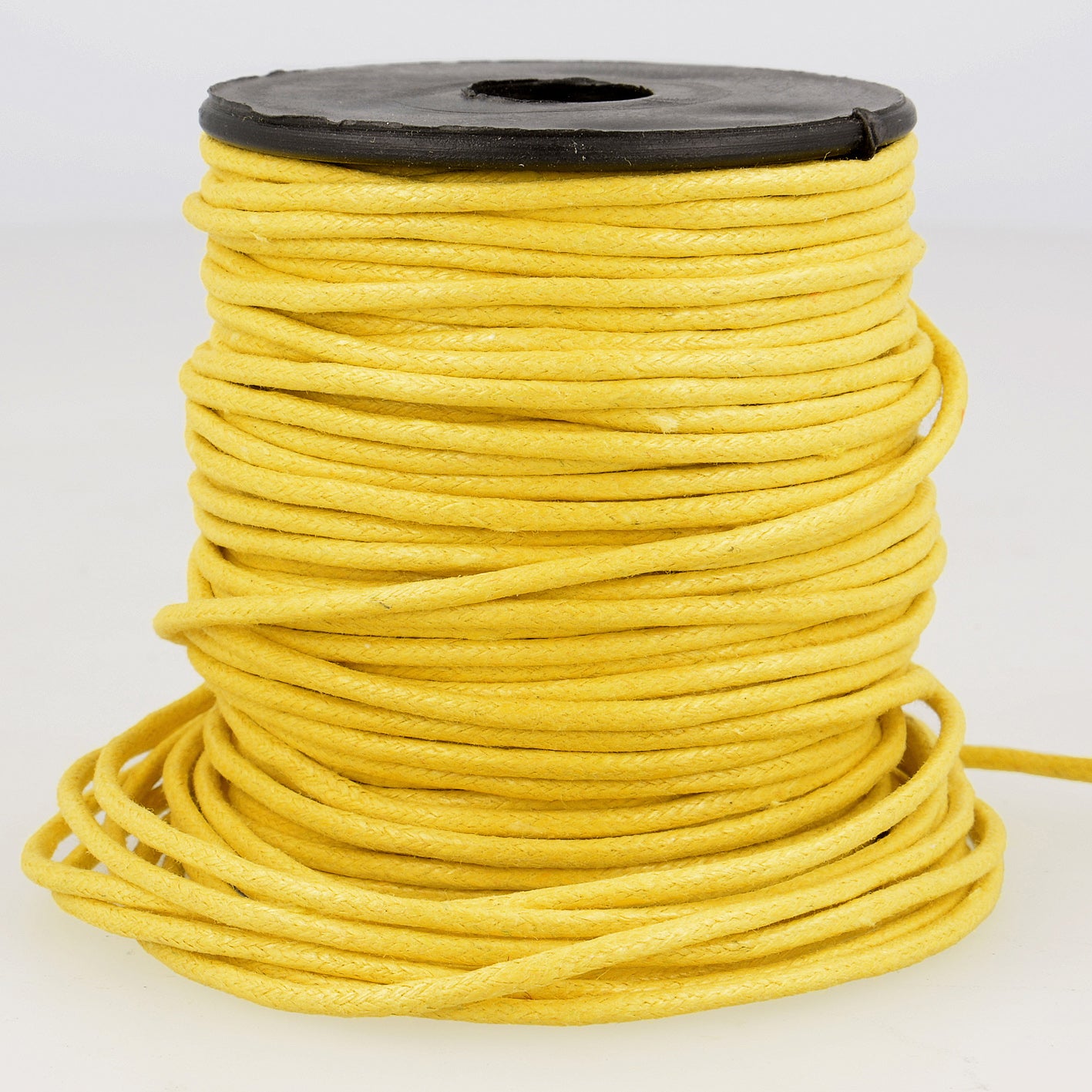 Spool of 2mm yellow faux leather cord with a textured finish for jewelry and garment projects.