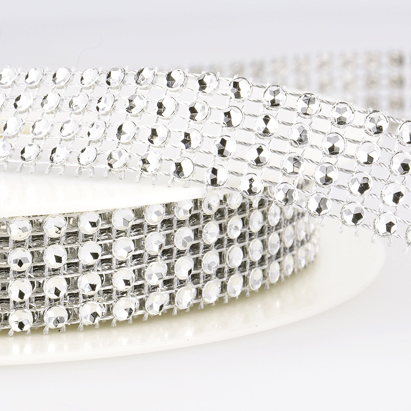 Silver crystal bead mesh trim with shimmering diamante stones on a flexible silver backing.