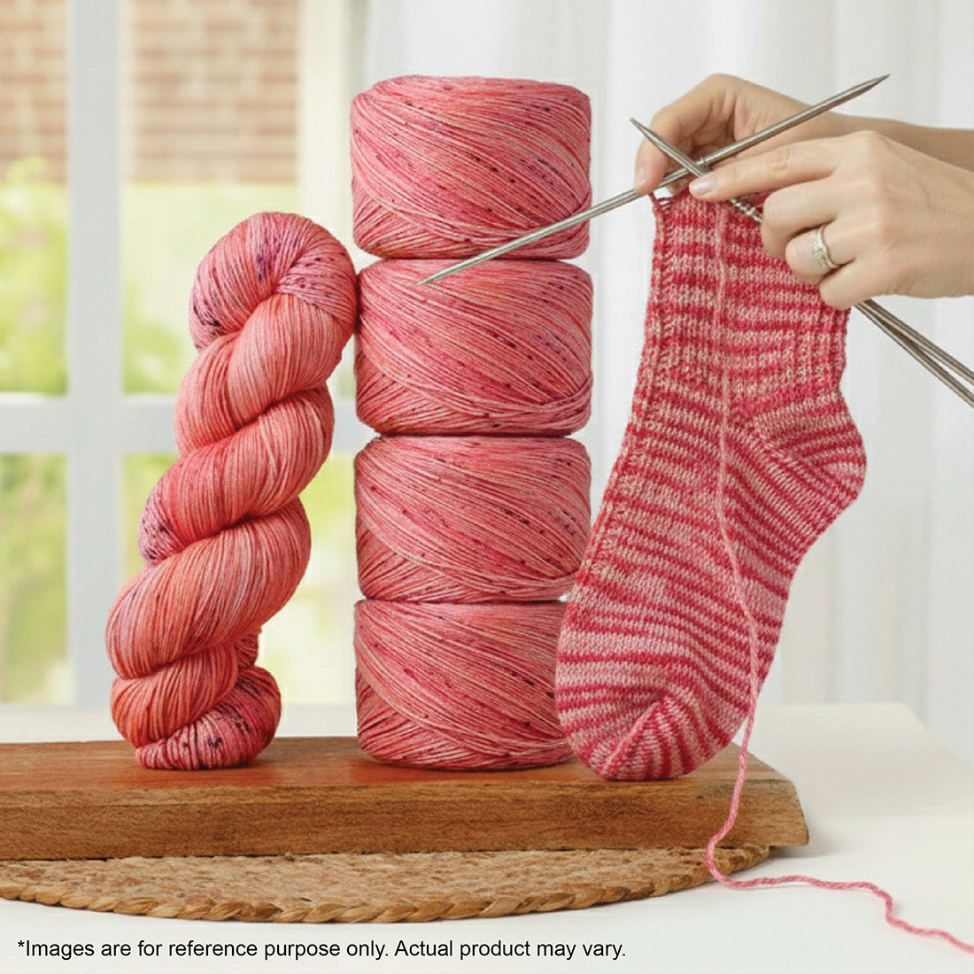 Pink variegated Terra 100g sock yarn in a skein, cakes, and a partially knitted sock on needles.