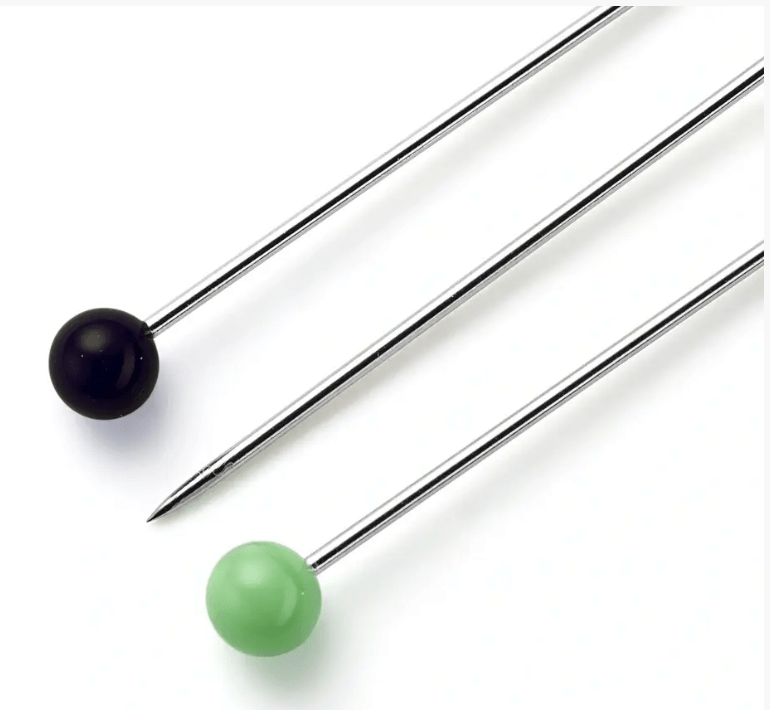 Three sewing pins with metal shafts and colored glass heads in black and green.