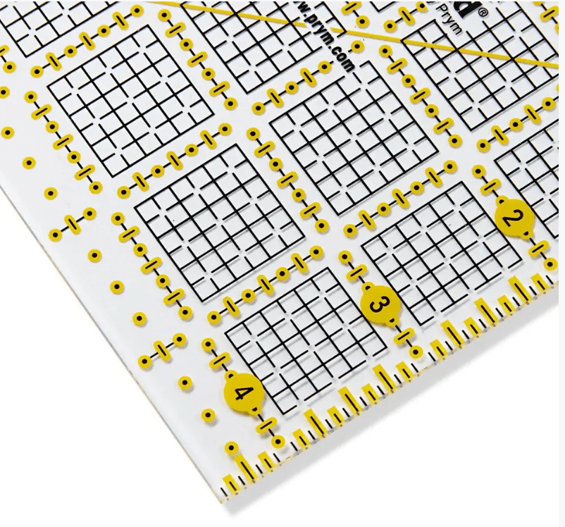 Transparent plastic ruler with yellow grid markings and inch measurements.