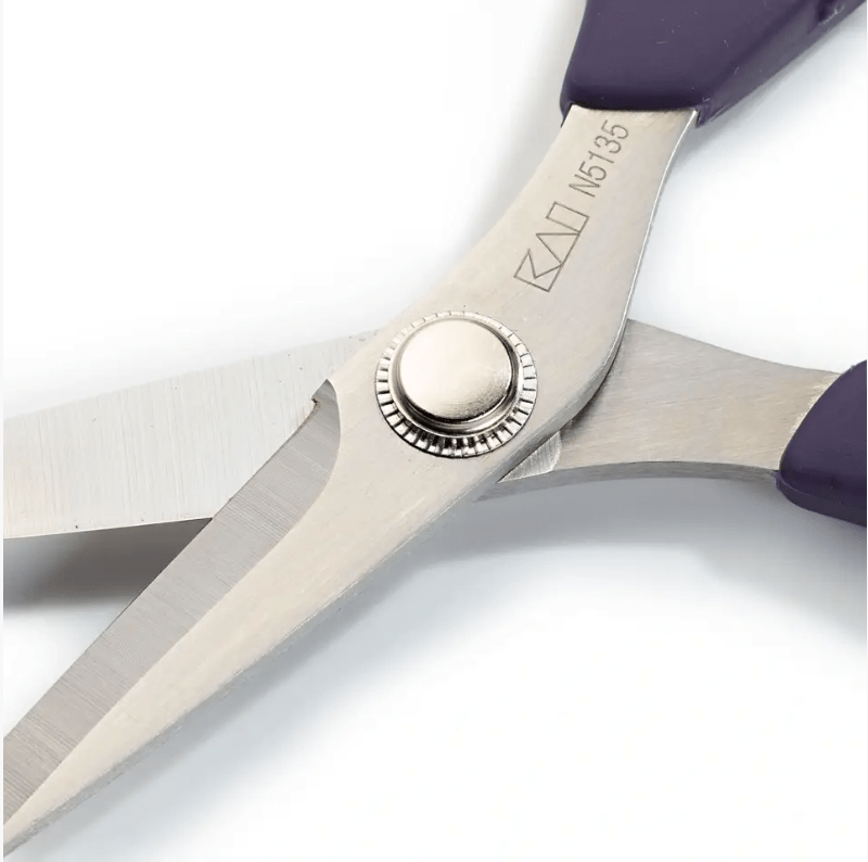 Close-up of purple-handled stainless steel scissors with KAI N5135 marking.