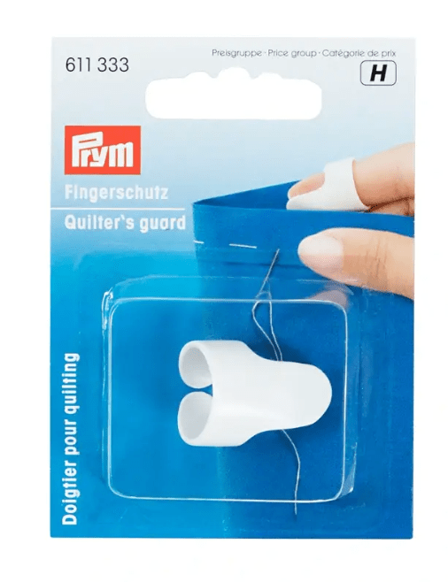 White plastic quilter's finger guard for protecting fingers during sewing.