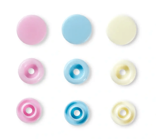 Nine assorted color plastic snap fasteners in pink, blue, and yellow.