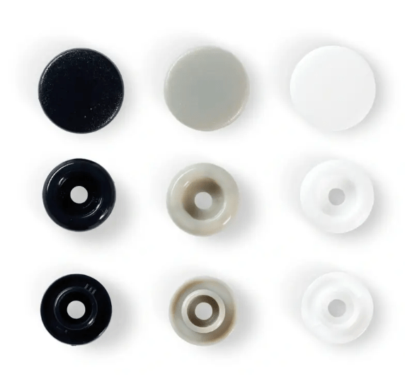 Assorted plastic snap fasteners in black, grey, and white.