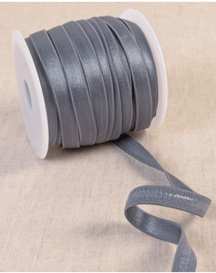 Grey coated elastic tape on a spool, made of polyester, silicon, and spandex.