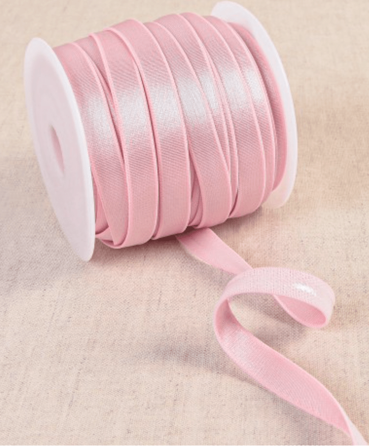 Pink coated elastic tape on a spool.
