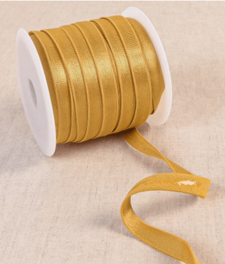 A spool of golden coated elastic tape with a visible end.