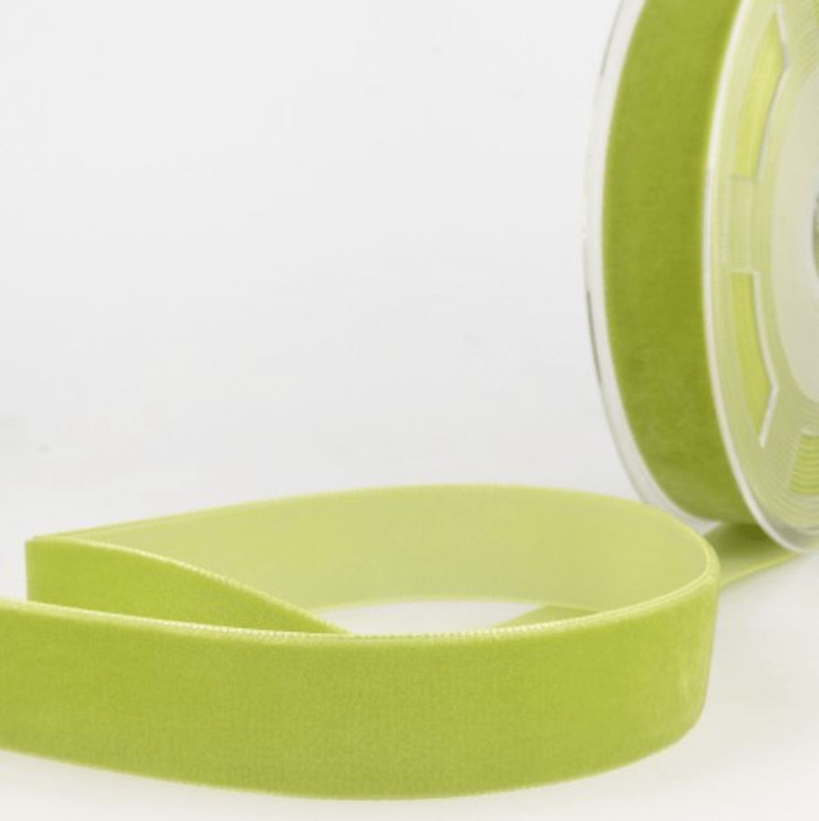 A roll of light green velvet ribbon with a soft texture.