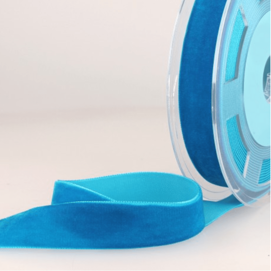 Turquoise velvet ribbon on a spool.