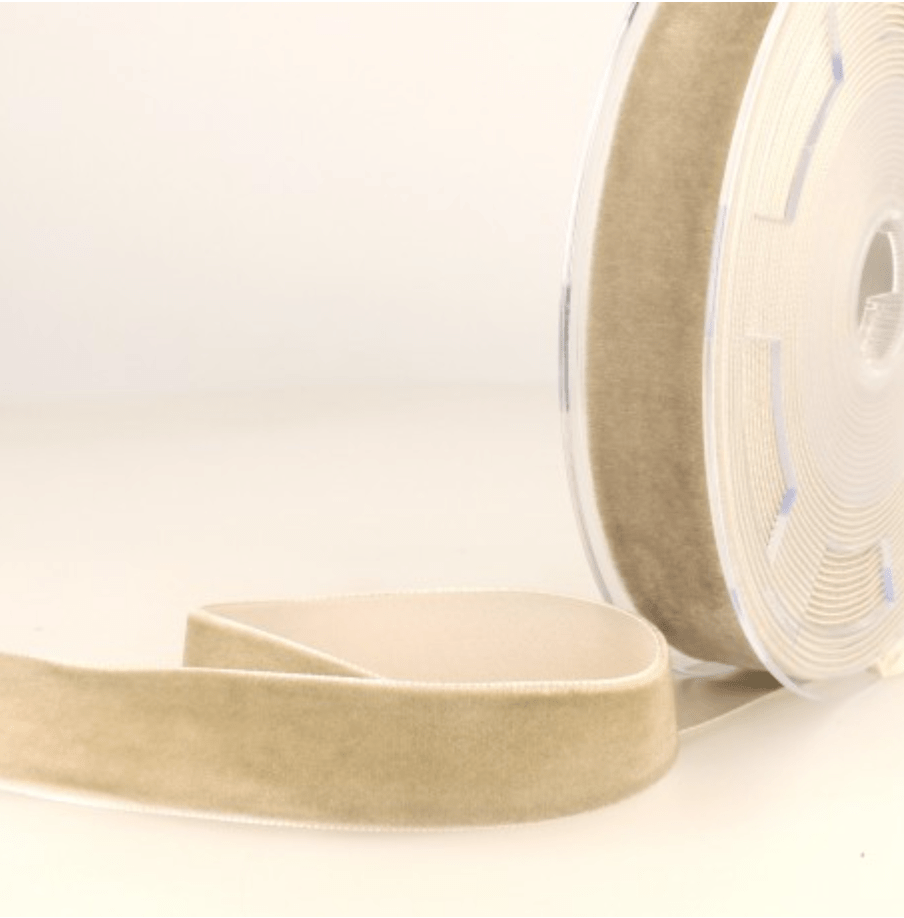 A roll of beige velvet ribbon with a white edge.
