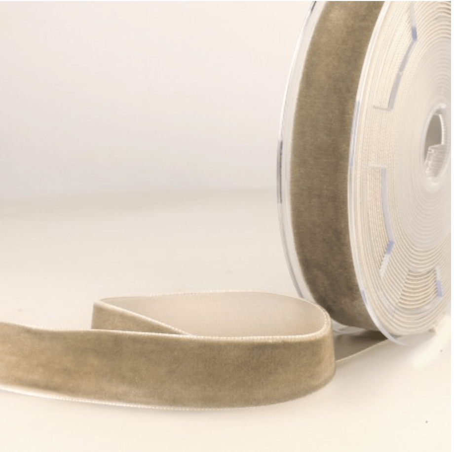 A spool of taupe velvet ribbon with a soft texture.