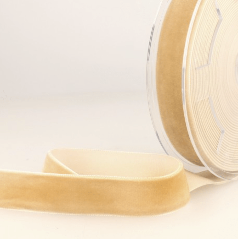 A roll of light brown velvet ribbon with a smooth texture.