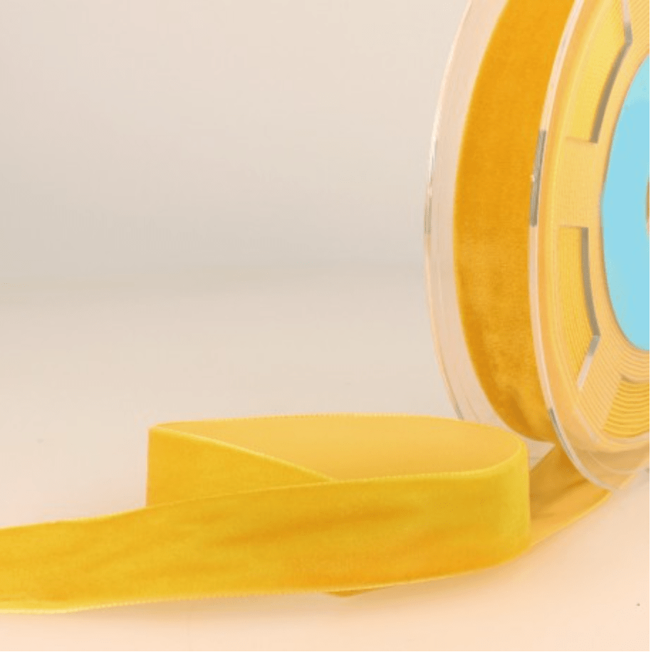 Yellow velvet ribbon on a spool.