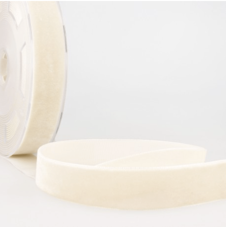 A roll of cream velvet ribbon with a soft texture.