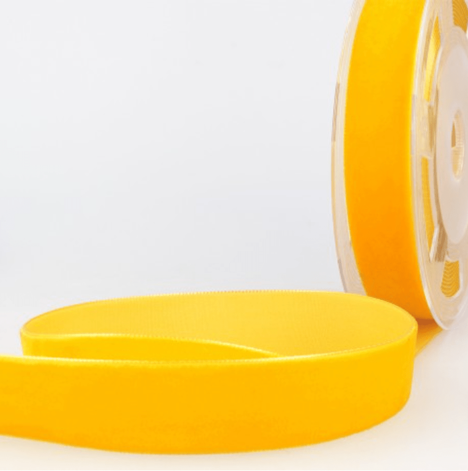 A roll of bright yellow velvet ribbon with a smooth texture.
