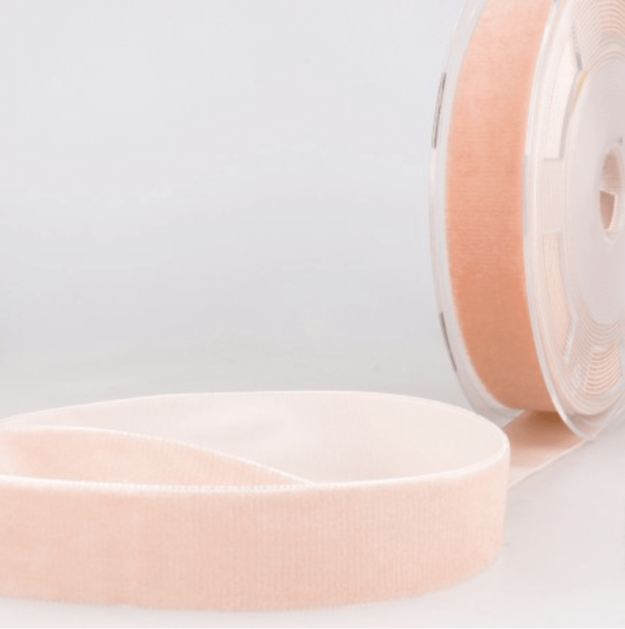 A roll of peach velvet ribbon and a length of the same ribbon.