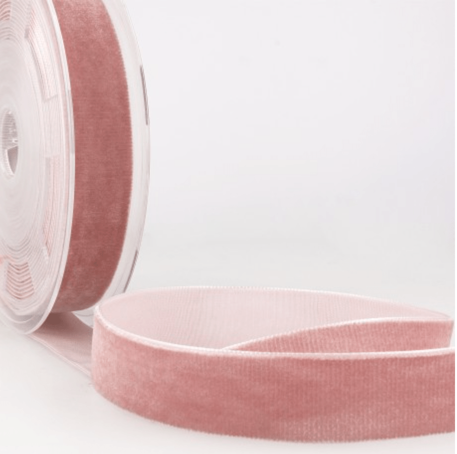 A roll of dusty rose velvet ribbon with a soft texture.