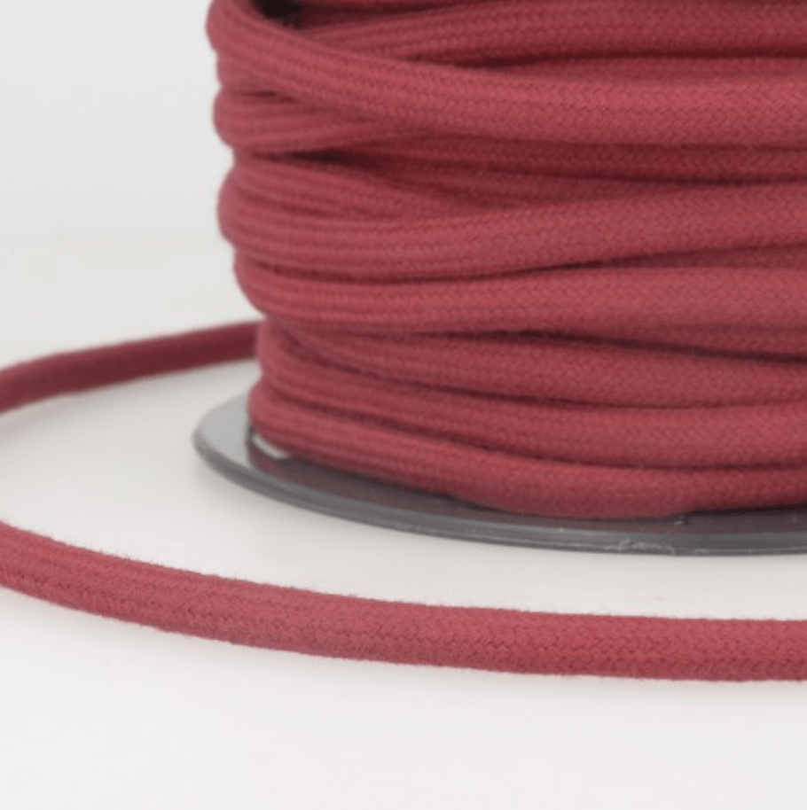 A spool of burgundy 4mm 100% cotton cord for crafts.