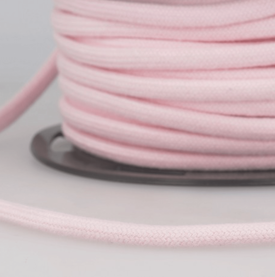 A spool of light pink 4mm cotton cord for crafts.