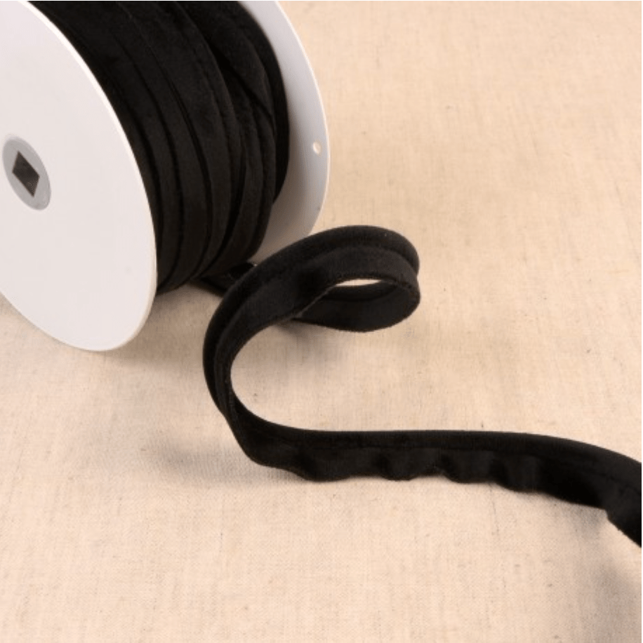 Black velvet piping cord on a white spool.