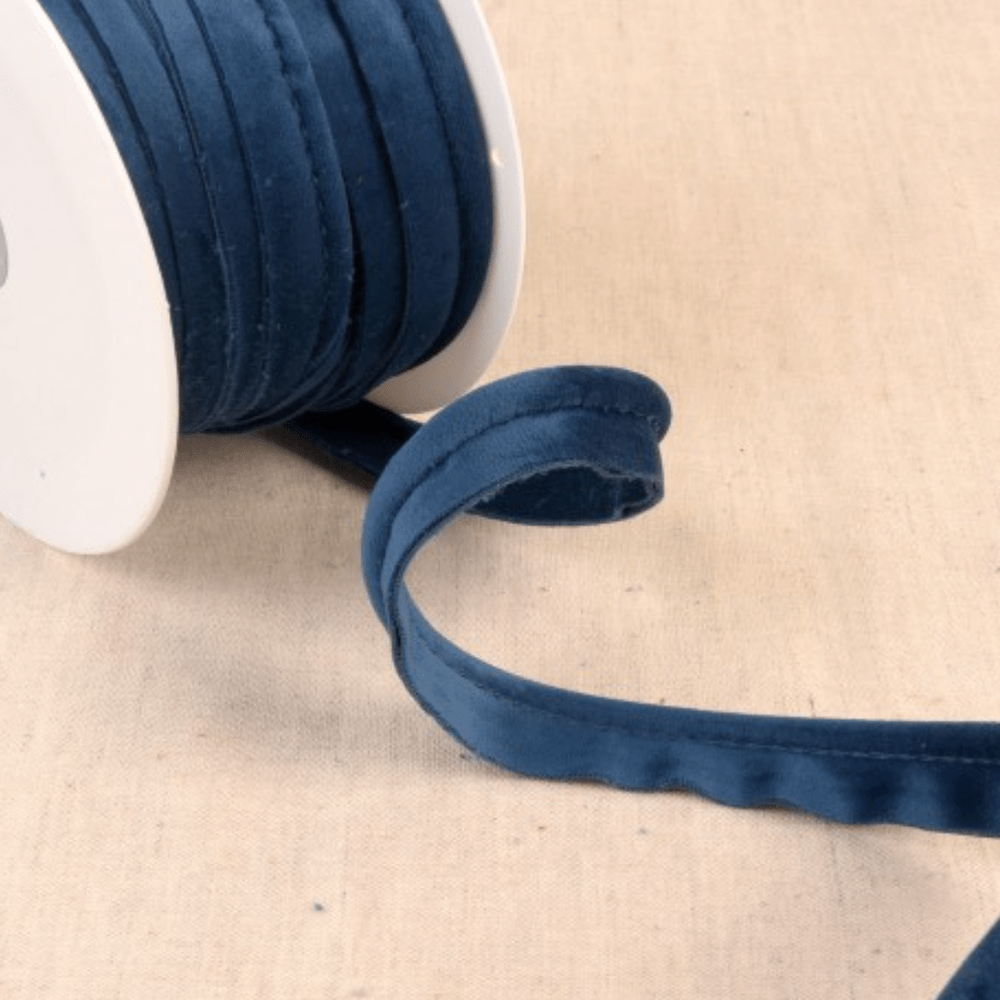 Dark blue velvet piping cord on a white spool.