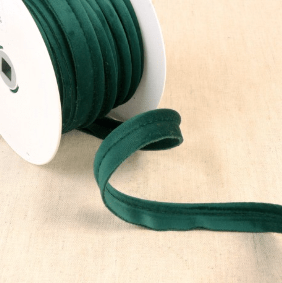 Dark green velvet piping cord on a white spool.