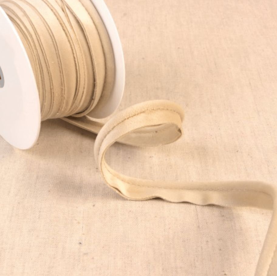 Stephanoise velvet piping cord in a light beige color on a spool.