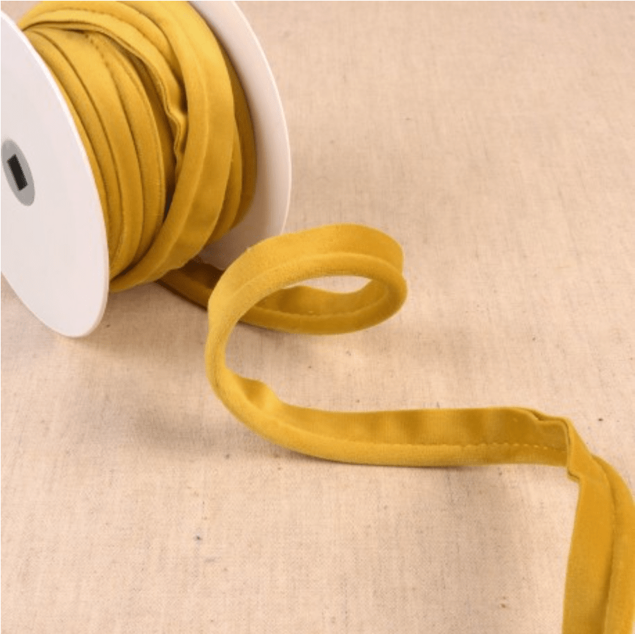 Yellow velvet piping cord on a white spool.