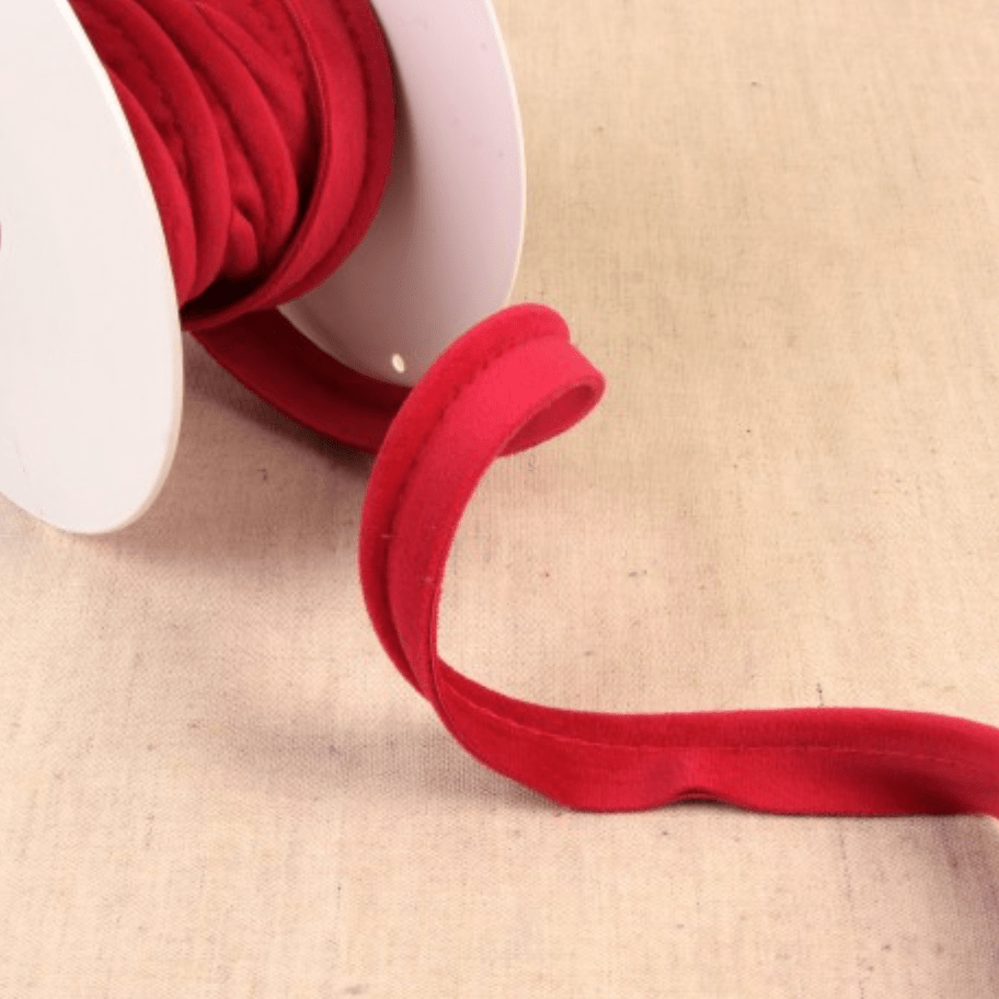 Red velvet piping cord on a white spool.
