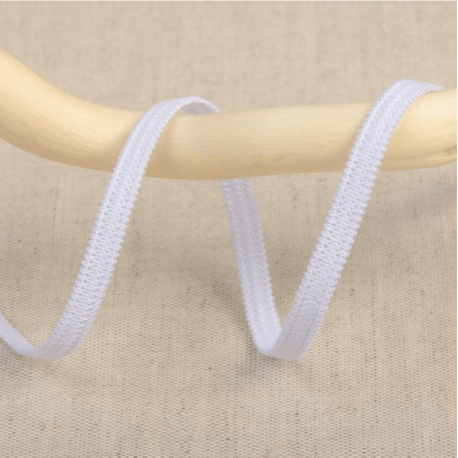 White elastic ribbon with a textured weave on a wooden dowel.