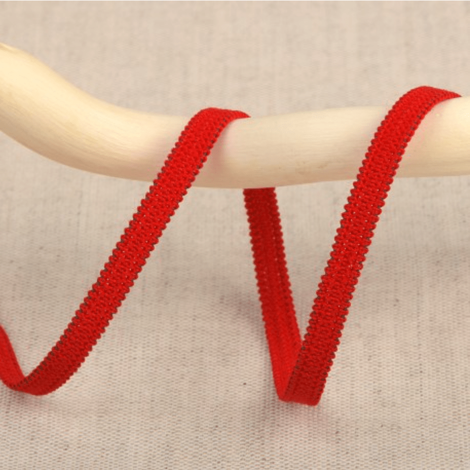 Red elastic ribbon with a textured edge on a wooden dowel.