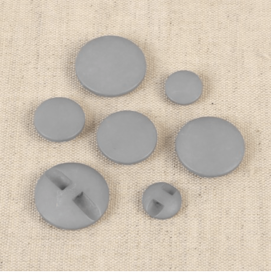Set of seven grey polyester buttons of various sizes, some with two holes.
