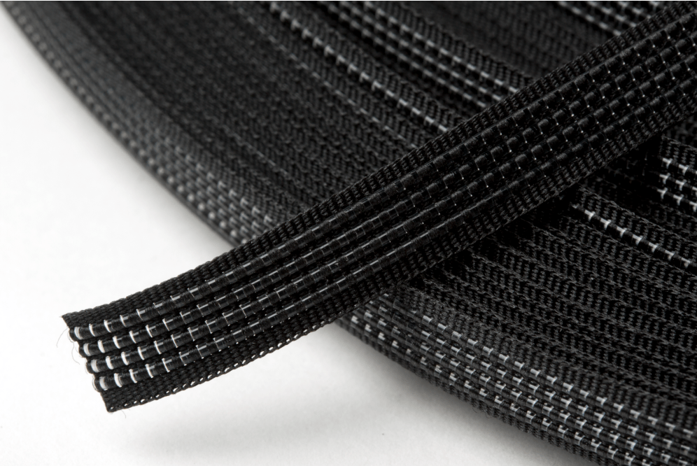 Black polyester boning with white stitching, coiled and a strip in the foreground.