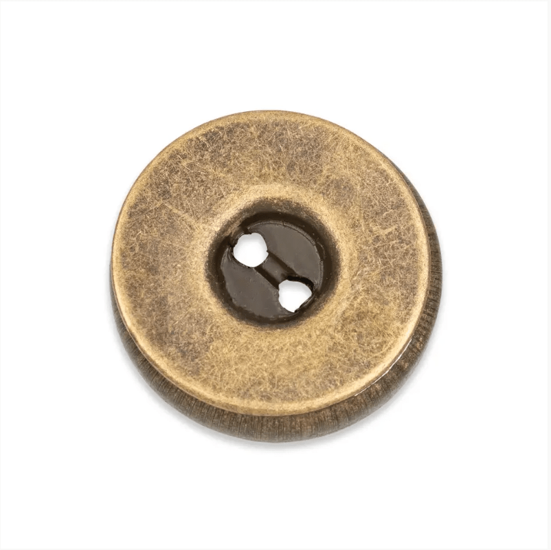Round brass-look metal button with two holes and a dark center.