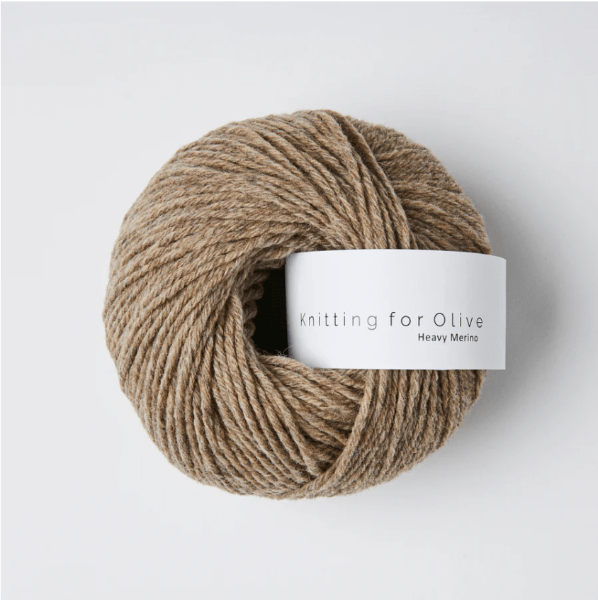 A ball of rustic brown Heavy Merino wool yarn with a white label.