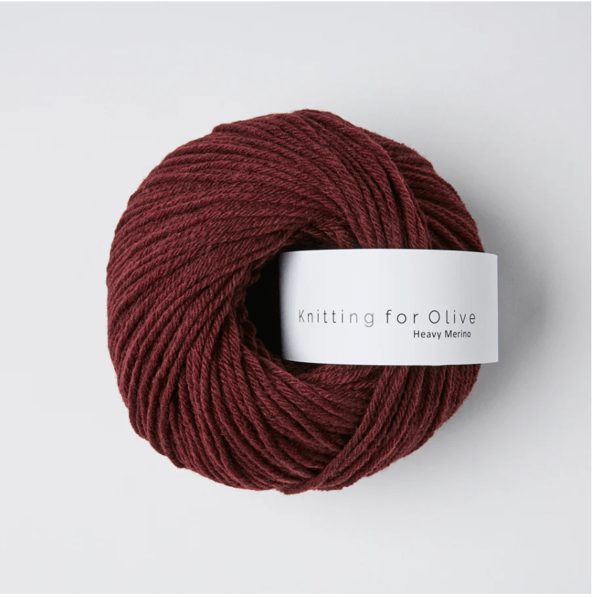 A ball of dark red Heavy Merino wool yarn with a white label.