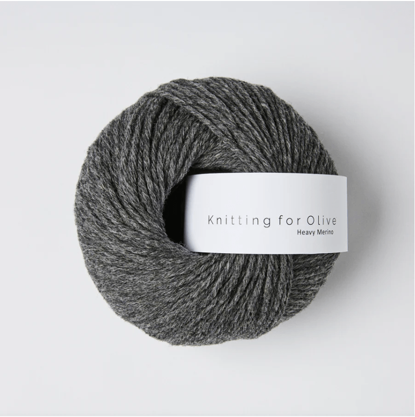 A ball of dark grey Heavy Merino wool yarn with a white label.