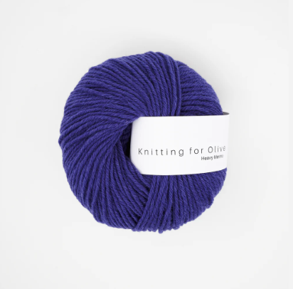 A ball of dark purple Heavy Merino wool yarn with a white label.