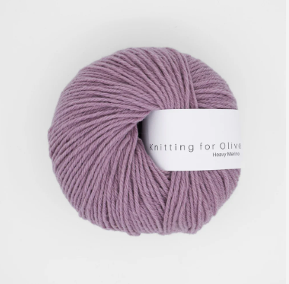 A ball of dusty rose Heavy Merino wool yarn with a white label.