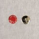 Red and silver metal buttons on a white background.