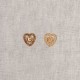 Two heart-shaped buttons with rhinestones on a textured background.